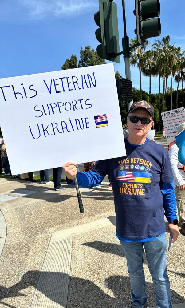 This protestor is holding a sign that reads: This Veteran supports Ukraine 🇺🇦 