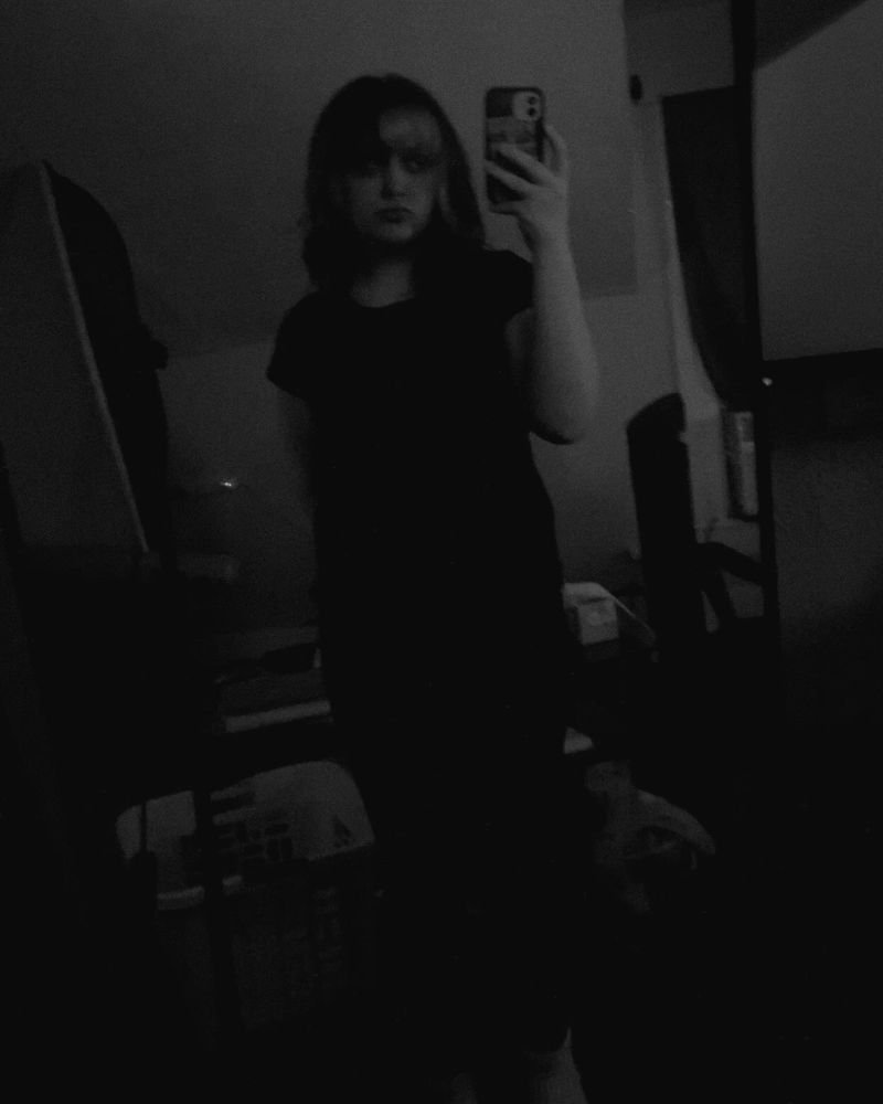 Black and white low light full body mirror selfie, neutral expression + pose