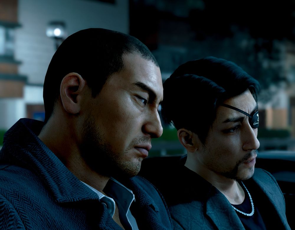 Screenshot of Majima and Saejima standing beside each other on a dark, empty street, leaning their heads towards one another