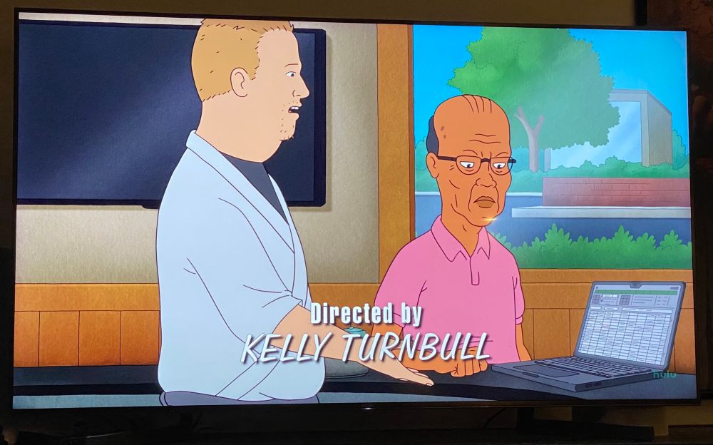 Screenshot from King of the Hill season 14 episode “Peggy’s Fadeout”, Bobby shows a laptop with a spreadsheet open to Ted Wassonasong, Chyron reads “Directed By Kelly Turnbull”