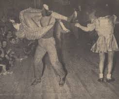 Two Dancers in a vintage newspaper photo doing the jitterbug, a man is swinging around his dance partner up around his head