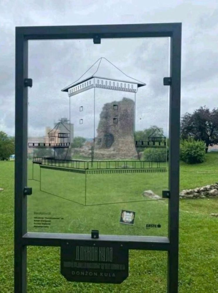Old ruin viewed through a glass frame with the original outlines of the building etched onto the glass