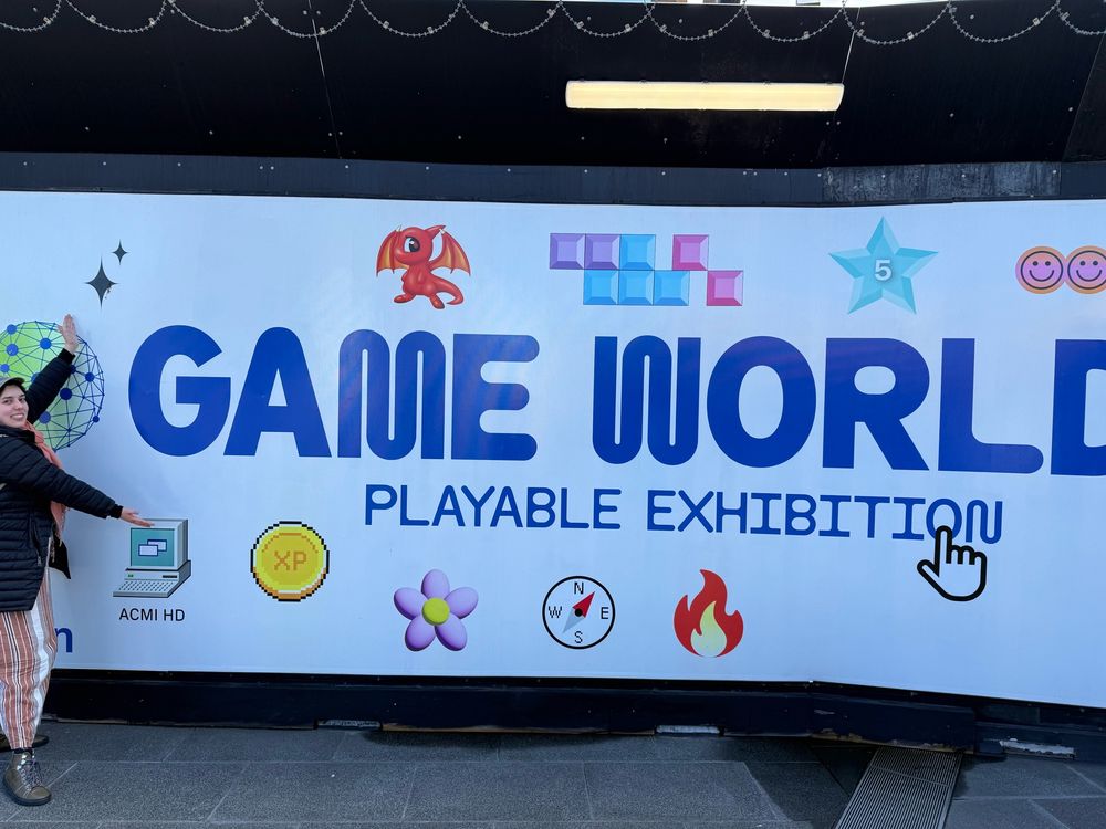 Me standing in front of the GAME WORLDS sign