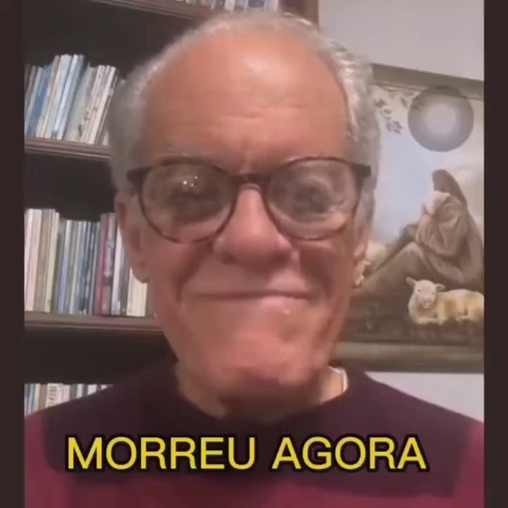 a man wearing glasses says morreu agora in front of a picture of jesus