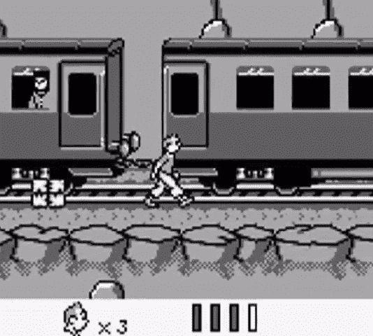 Capture d’écran du premier niveau de Tintin au Tibet sur Game Boy. On y voit Tintin qui marche le long du train, un passager à la fenêtre, et un colis au milieu du passage.