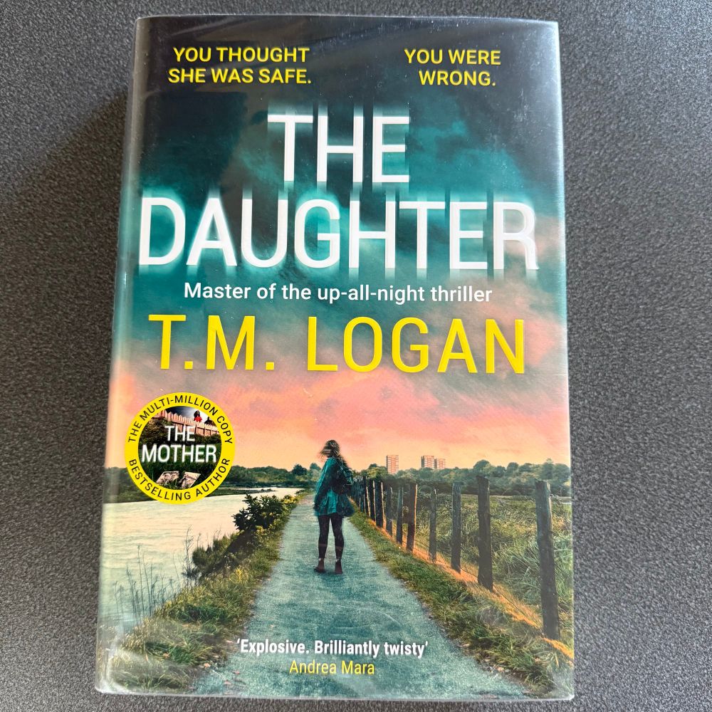 Book cover picture shows a girl standing on a riverside pathway. Book tagline is you thought she was safe, you were wrong 