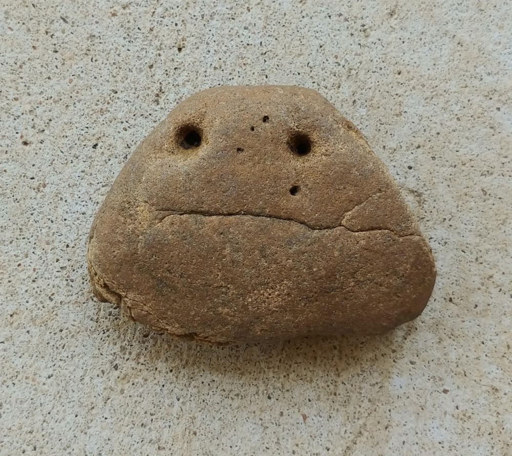 Rock with two holes for eyes and a crack for a mouth