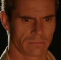 A screenshot of the character Roberto Àvila (played by Tony Dalton without mustache). He's staring in the void with a very severe expression.