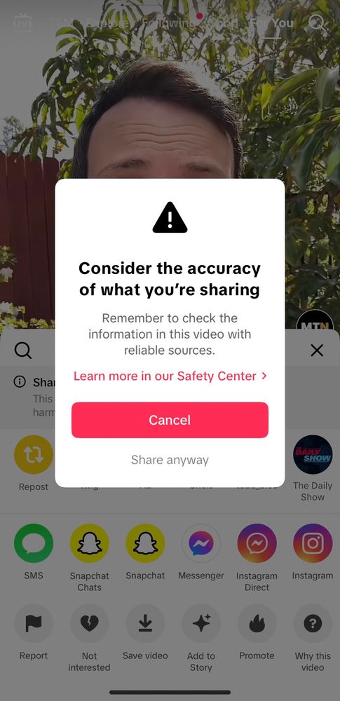 A TikTok warning message appears over a paused video of one of the Meiselas brothers from Meidas Touch speaking outdoors, with trees and a wooden fence in the background. The warning reads, "Consider the accuracy of what you’re sharing. Remember to check the information in this video with reliable sources." Another message says sharing is limited to one chat at a time to help limit the spread of potentially harmful content. The video discusses information related to the North Carolina Supreme Court race.