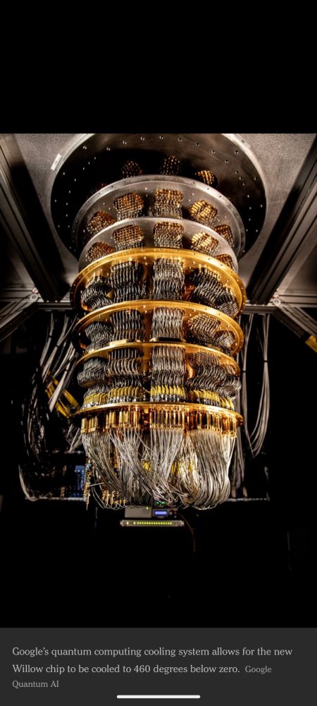 An image of a quantum computer. It has long cascading silver cables with gold bands.