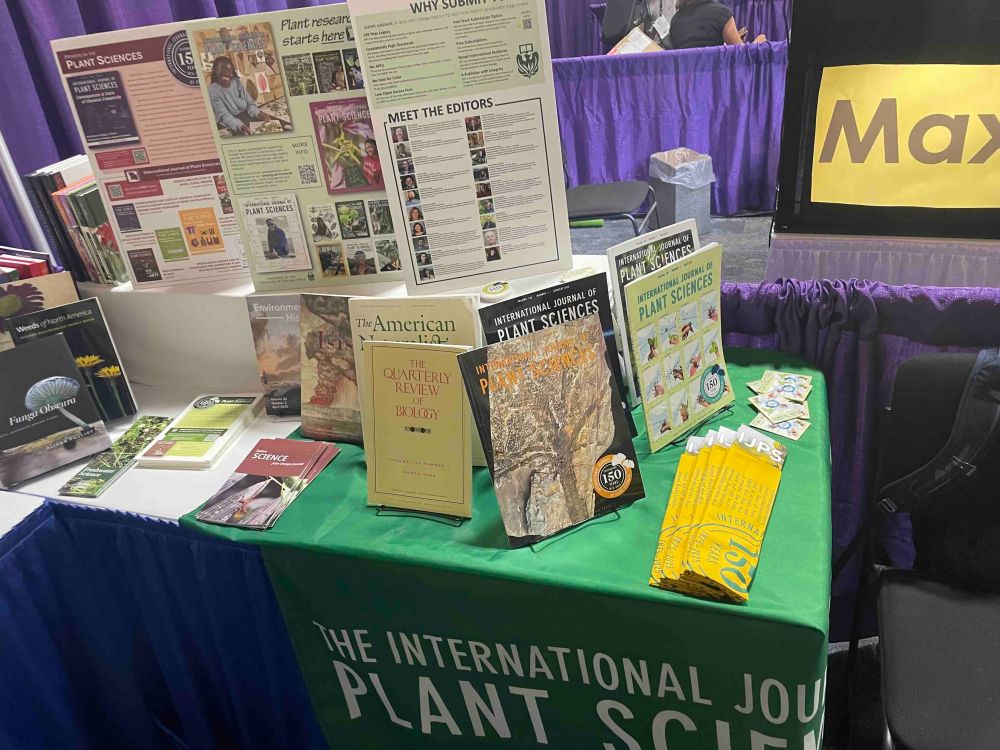Photo of booth featuring IJPS journal issues and swag.