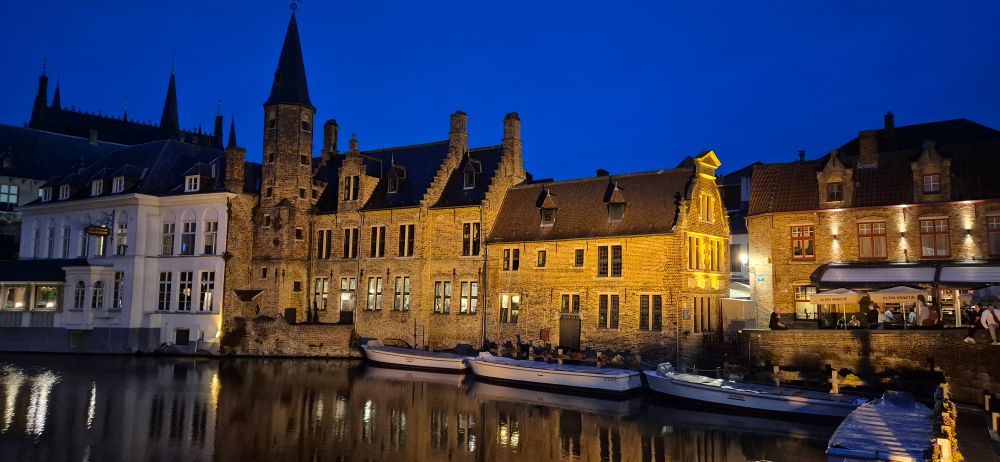 Nighttime picture of illuminated building next to the canal in Bruges 
