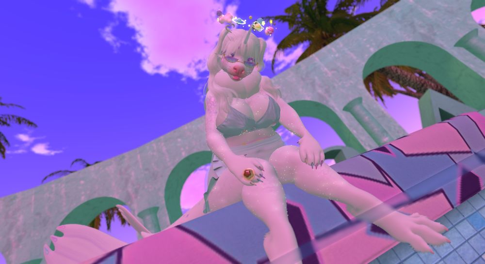 An anthro white seal sat at the edge of a pool, their flippers dipped into the water.