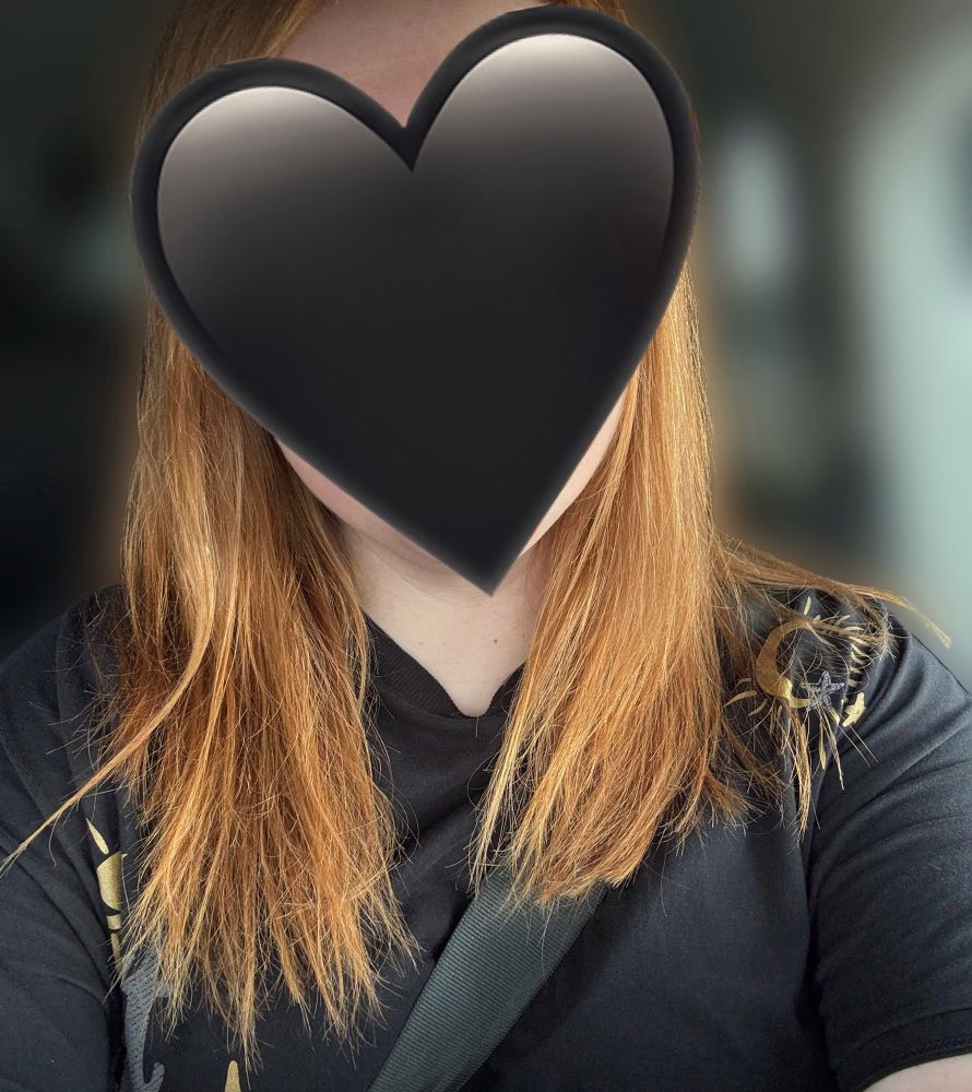 (Parked) car selfie of Red with a black heart over her face and the background blurred