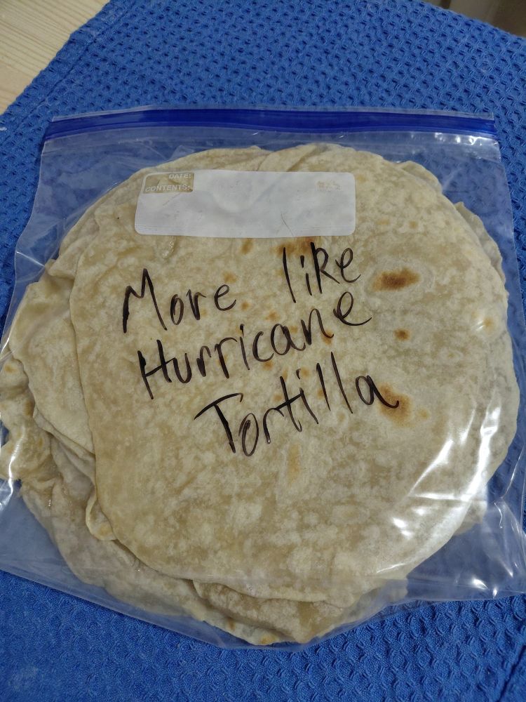 A stack of fresh flour tortillas in a gallon sized ziploc.  I have written "more like hurricane tortilla" on the baggie because I am a cringe millenial. 