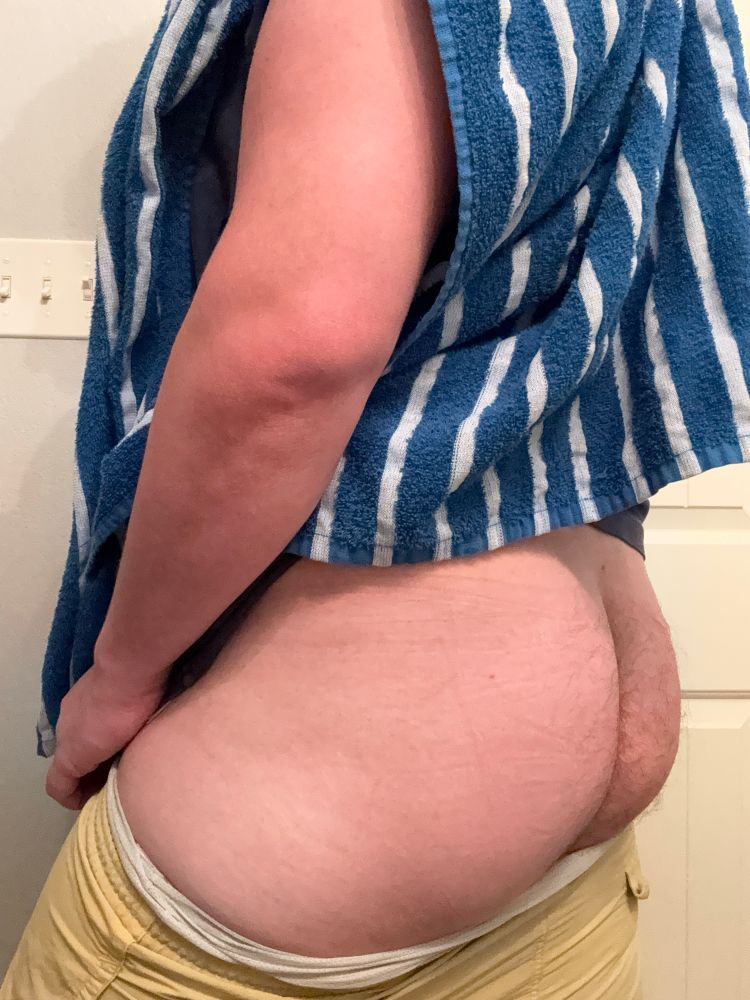 Mans butt above yellow swim trunks 
