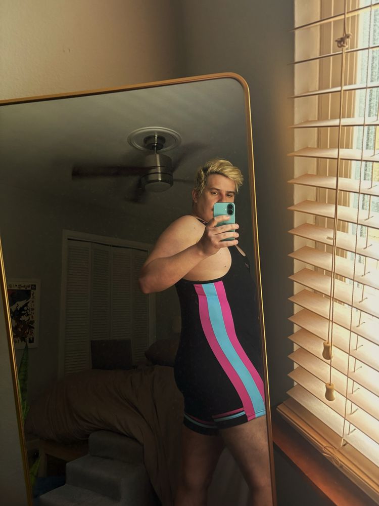 Man in black and pink and blue singlet with blonde hair