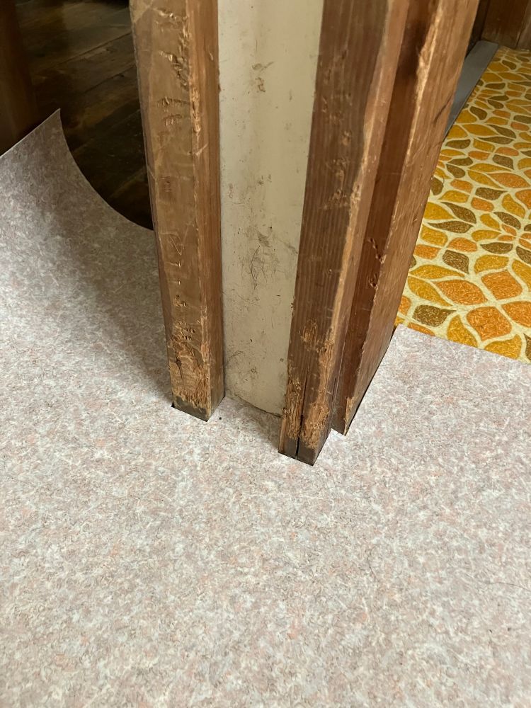 床の写真。新しく貼るシートを、柱の凹凸に合わせて切って嵌めてみたところ。