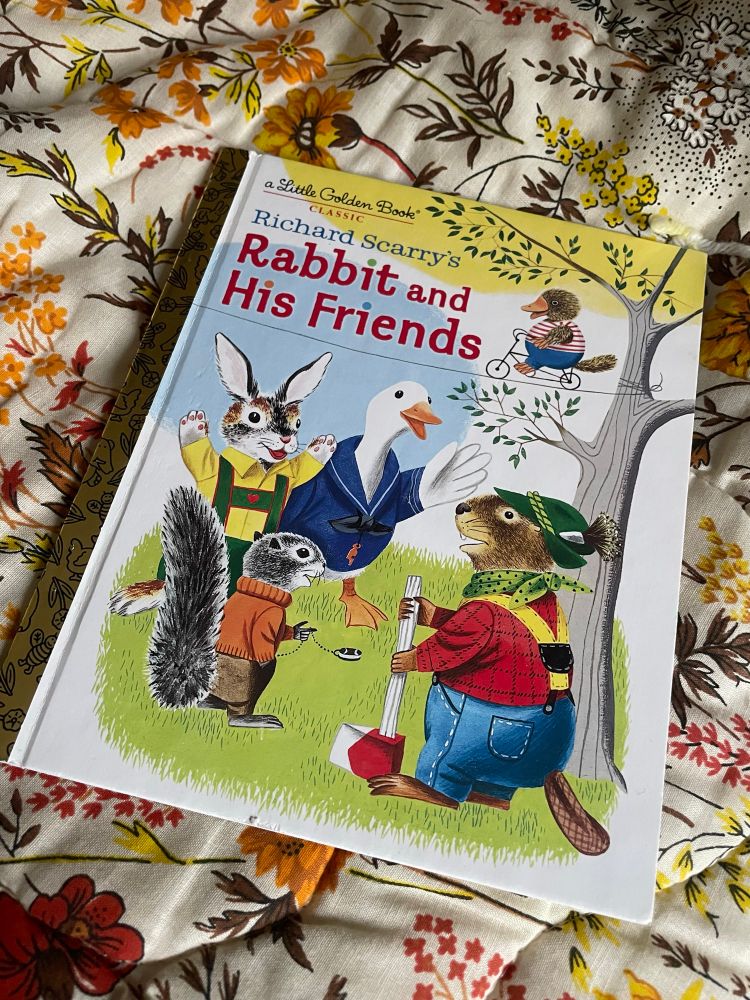 Copy of Richard Scarry’s Rabbit and His Friends little golden book laying on a vintage floral blanket 