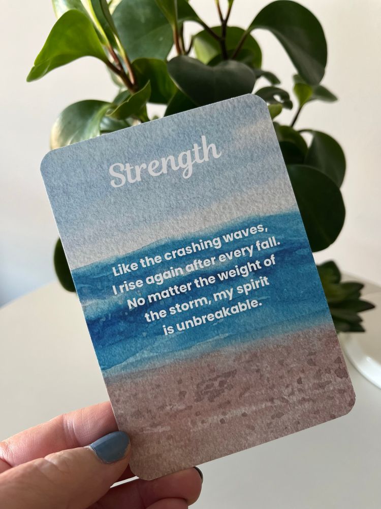 A daily affirmation card from my spirit of the sea deck, that says strength, like the crashing waves, I rise again after every fall. No matter the weight of the storm, my spirit is unbreakable. The background is an ocean scene created with my watercolor painting.