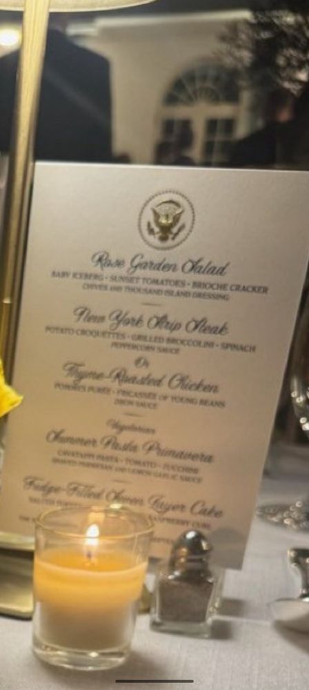 And then you from a dinner held at the rose garden at the White House that lists a garden salad called the rose garden salad with some illegible ingredients and frankly very uninspiring ingredients. As well as a New York strip steak, a thyme-roasted chicken and a something, something from a vera followed by a fudge-filled layer cake as the dessert. Summarizing what some might expect to have been, the least fancy fancy meal to have ever had in the rose garden.