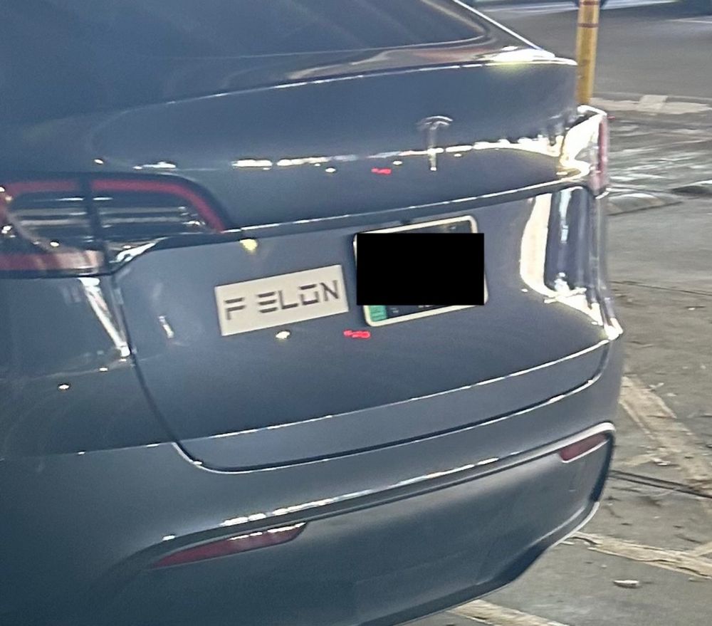 Picture of Tesla car with bumper sticker to left of license plate that says “F ELON” done in typeface Tesla uses in their advertising.