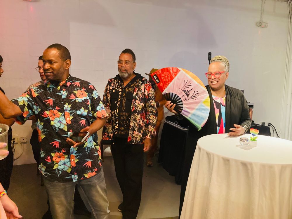 Rayceen waves a World Pride fan as the crowd mingles. Rayceen is the Empress of Pride. 