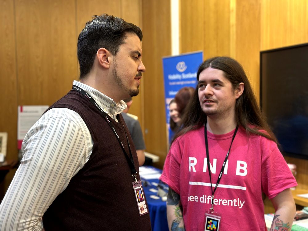 Matthew and Conor from RNIB having a wee chat at the event. Conor is wearing a pink "RNIB" branded t-shirt.