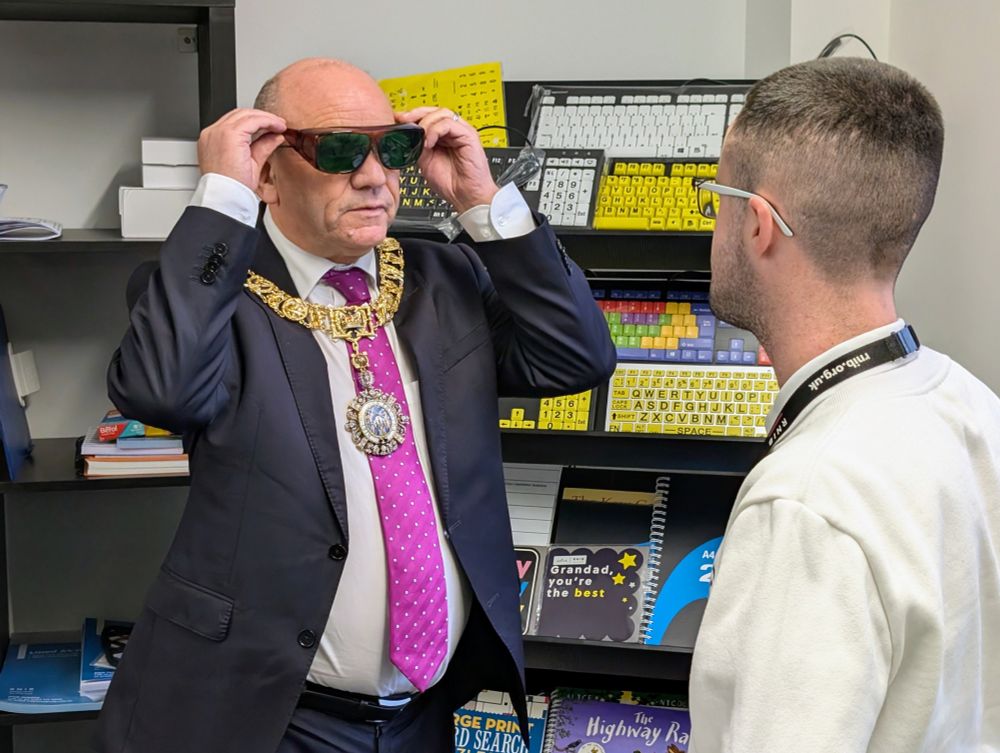 The Lord Provost tries on a pair of green eye shields while Daryl looks on.