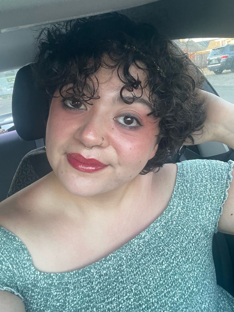 Sol is smiling in a selfie wearing a green dress