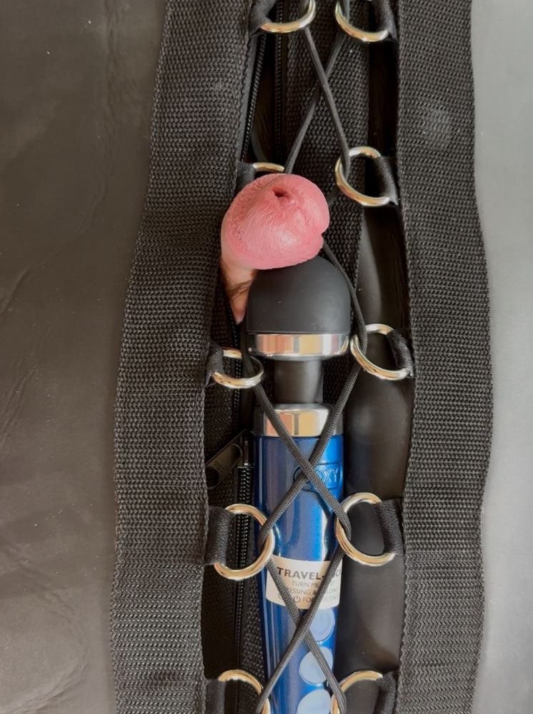 Switchybear94’s hard cock pulled out of the neoprene sleepsack, with a buzzy stick tightly laced to his cock for continuous stimulation. 