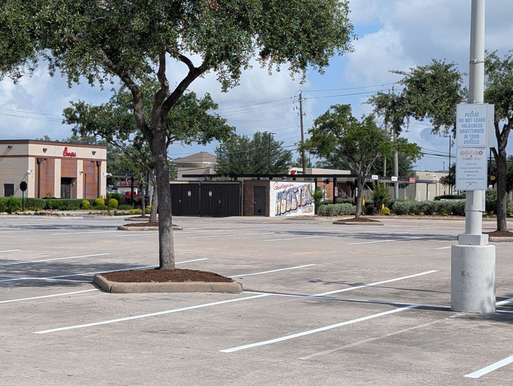 Welcome to Houston mural painted on a wall blocking a dumpster 