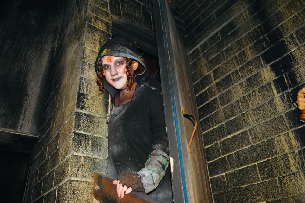 A photo of myself standing in between a door and brick wall at the haunted house. 