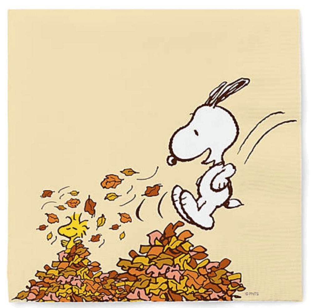 Snoopy and Woodstock jump in a pile of leaves 