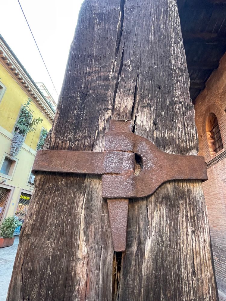 An iron restraint holding two large wooden posts together