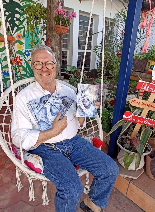<e sitting in a macrame swing in our garden holding up copies of my book. The Admin Project Earth.