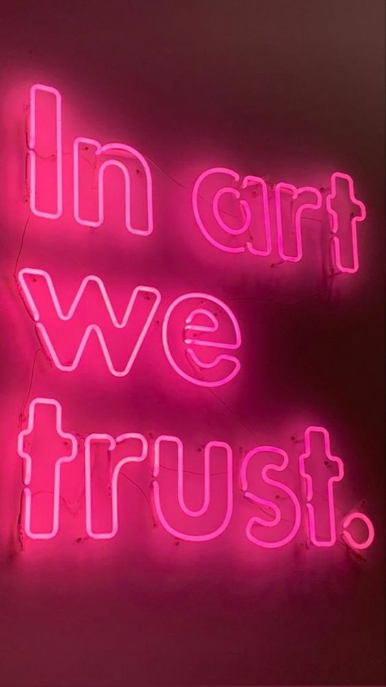 A pink neon sign that spells:

In art we Trust