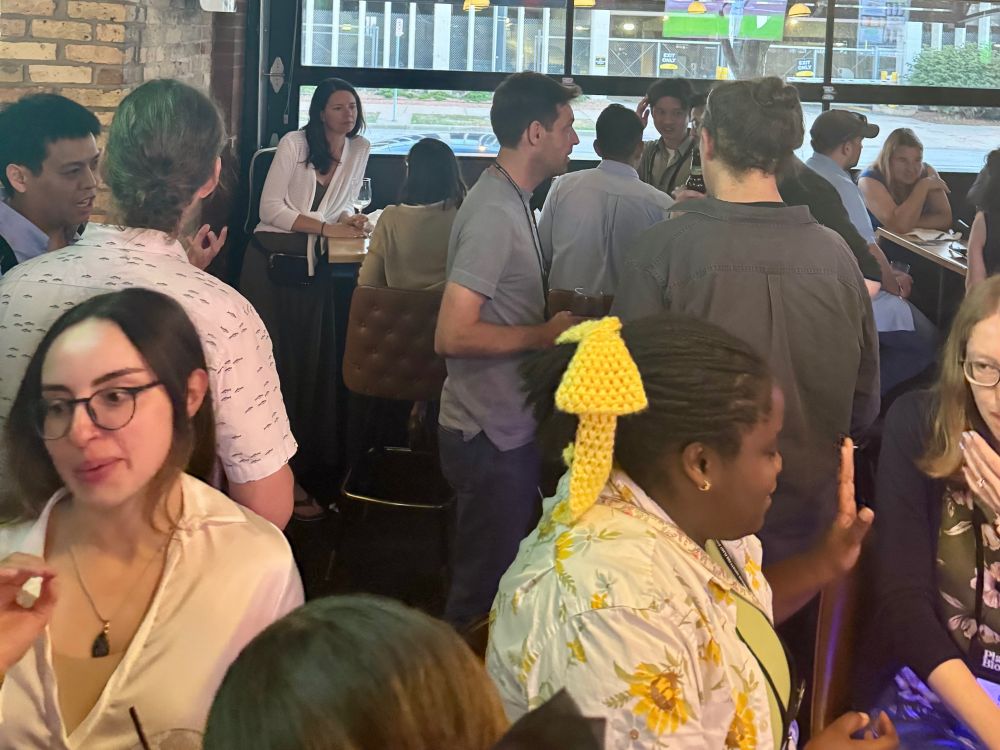 Attendees at the event pictured talking together in groups.