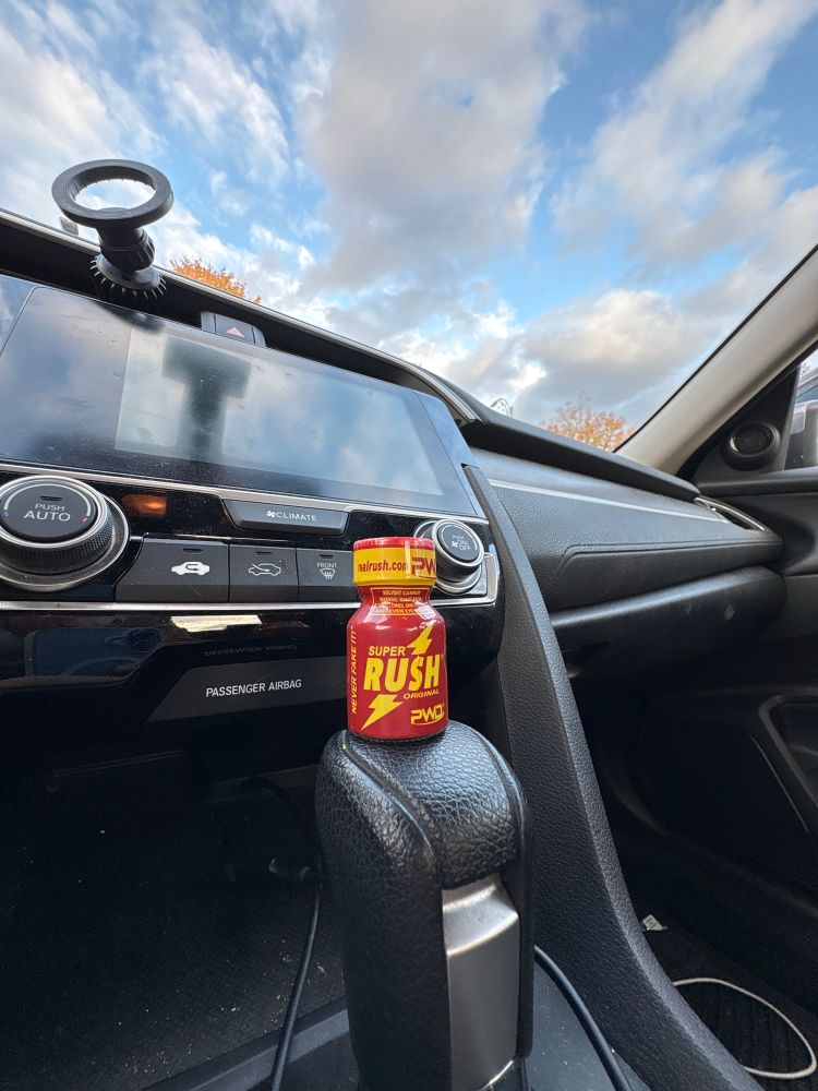 a 0.5 zoom photo of a bottle of poppers on the stick of my car