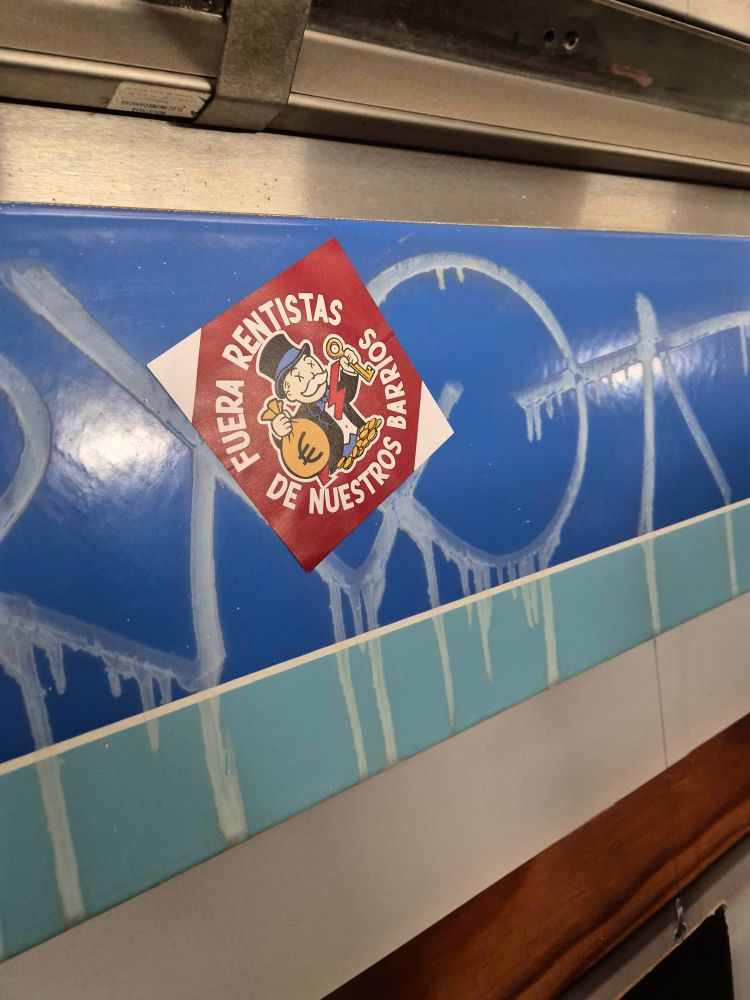 Pegatina con la imagen del rico del monopoly con el texto "Fuera rentistas de nuestros barrios"