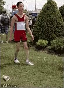 a man in a red and white outfit is walking on a grassy field ..