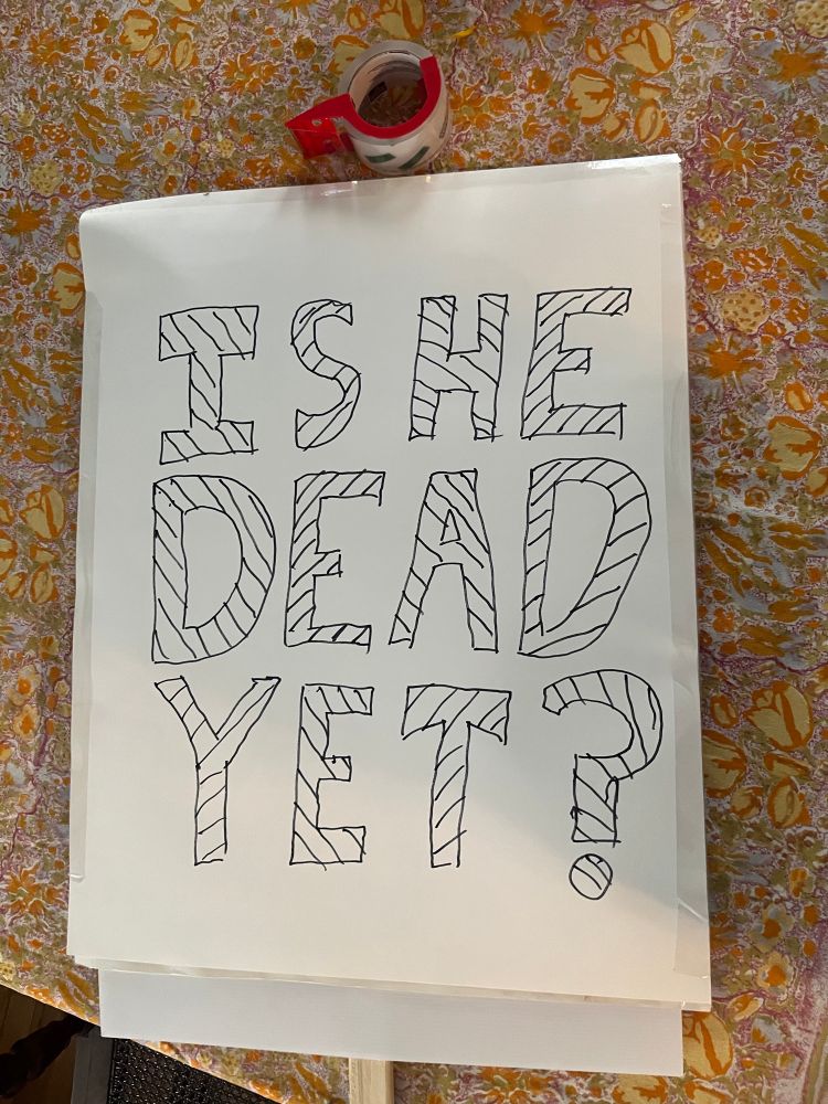 Large protest sign saying “is he dead yet?”
