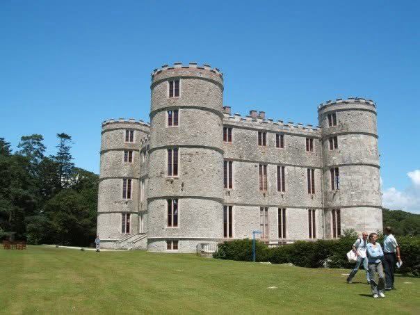Lulworth Castle, a square off-white castle with a round four-storey tower in each corner.
