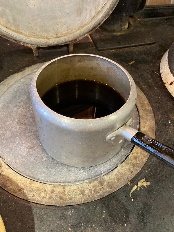 An elderly saucepan whose edges curve inwards rather than outwards, full of a dark liquid (alder ink) on the Aga's hottest hot plate. I didn't take any photos of the actual kitchen so take this picture of the Aga as representation of what this kitchen is like.