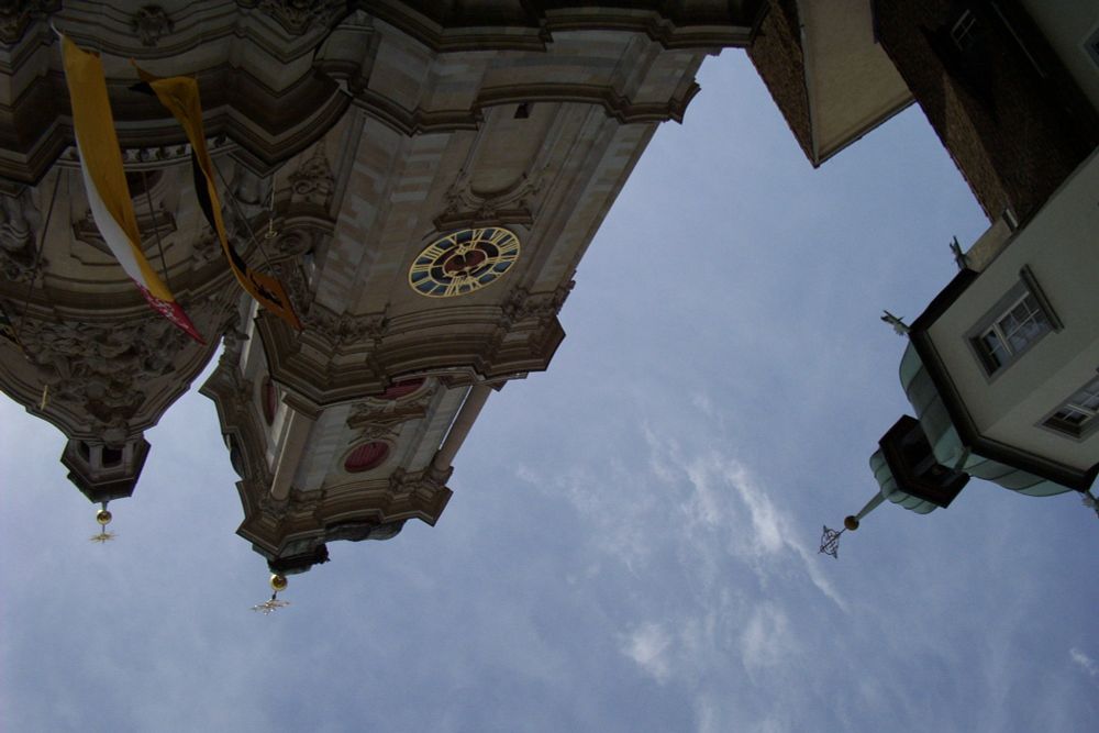The towers of the cathedral upside down, taken from a position lying on the grass below them.