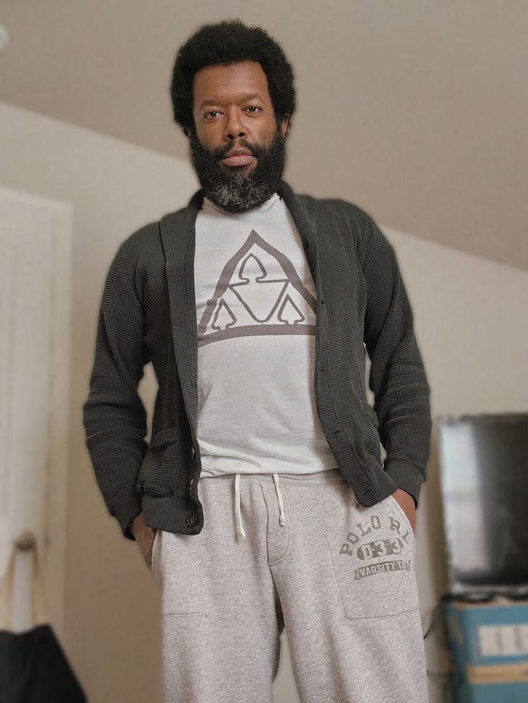 Standing in my room (fully dressed) with my hands in my pockets and wearing a stoic smile.