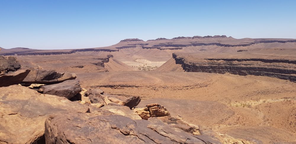 un paysage de vallée rocheuse complètement minérale sous un grand ciel bleu