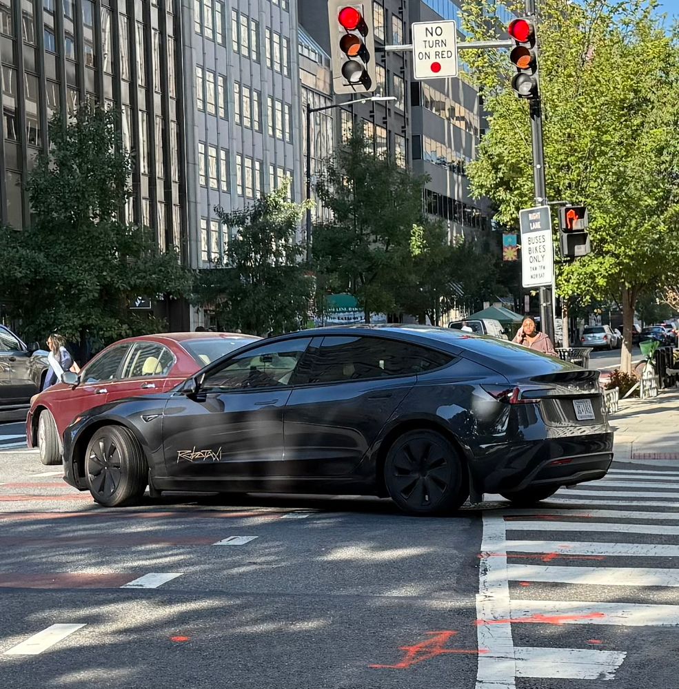 A grey robotaxi turning right 