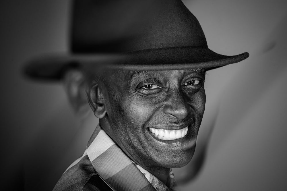 Black and white studio portraits of the same man, highlighting the textures of his suit, jewellery, and facial features. The lack of colour draws attention to contrast, expression, and detail, showing a more contemplative side of his personality.