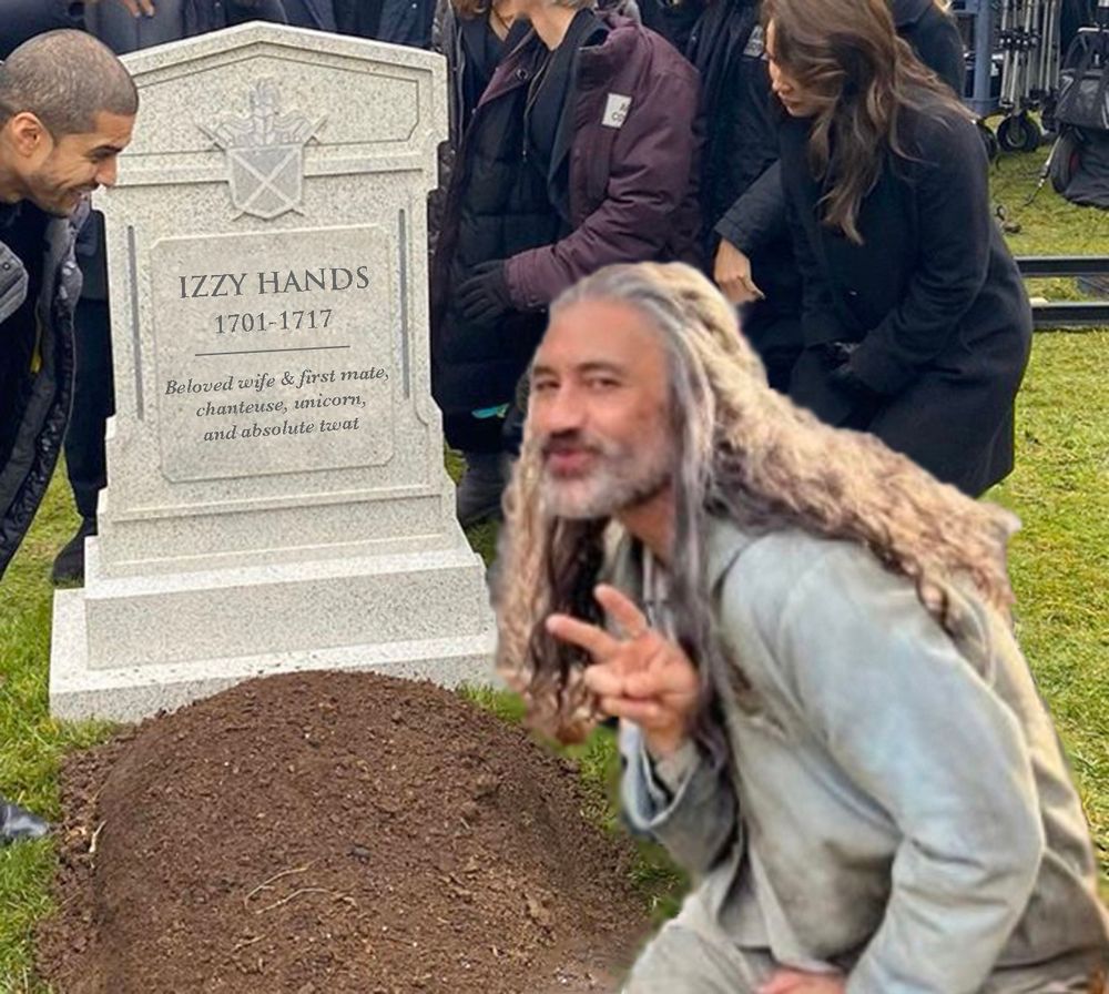 A version of the Grant Gustin Next to Oliver Queen's Grave meme. Taika Waititi is dressed as Ed Teach in his dirty-ass orphan outfit from S2. He is mugging for the camera and throwing a peace sign. He is crouching in front of a fresh grave, and the legend on the head stone reads: Izzy Hands, 1701-1717, Beloved wife & first mate, chanteuse, unicorn, and absolute twat.